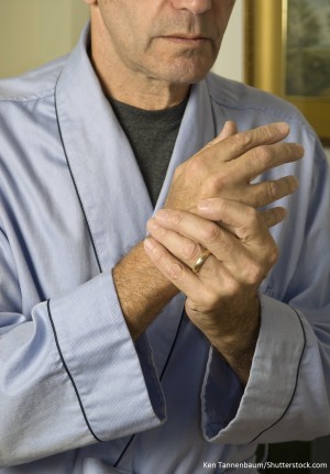 Older man holding wrist