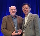 John O’Shea, M.D., (l) receives his award from ICIS President Tada Taniguchi, Ph.D.