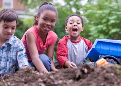 Photo of kids playing together in the dirt.