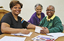 Community members Karen McDowell (left) and Janice Flemming (center) have their blood pressure checked by Chi Eta Phi nurse Gwendylon Johnson (right) at a recent Kidney Sundays event.