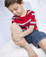 Young boy holding knee
