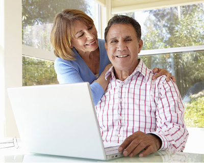 A elder couple look at a laptop
