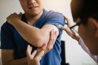 A doctor examining a patient's elbow